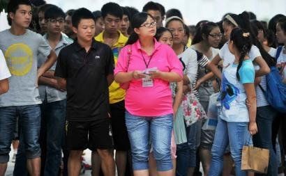 6月7日，雅安天全中學(xué)的呂莎莎老師(中)在考場(chǎng)外等待自己的學(xué)生出來。