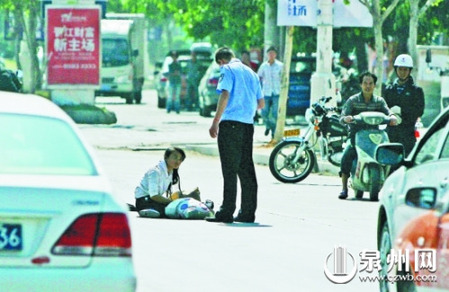 女孩從摩的上摔下，跌坐路中央，恰遇社區(qū)聯(lián)防巡邏人員扶起。