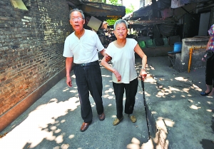 昨日，江北野水溝，92歲羅家強(qiáng)正扶著82歲老伴唐素芬散步鍛煉。 重慶晨報(bào)記者 李斌 攝