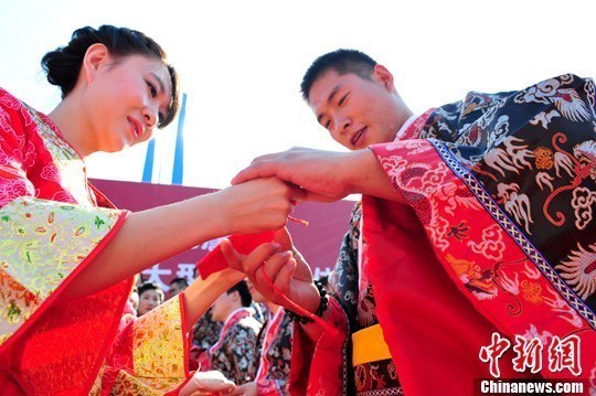 9月1日，一場別開生面的“重溫漢唐風”漢式集體婚禮在泉城濟南舉行，72名新人身著傳統(tǒng)漢服喜結(jié)良緣，并在許愿墻上許下“千年共枕眠，一世永相愛”心愿。圖為新人解纓結(jié)發(fā)。中新社發(fā) 張勇 攝