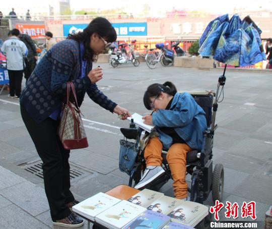 洛洛正在給買書的顧客簽名。 馮曉林 攝