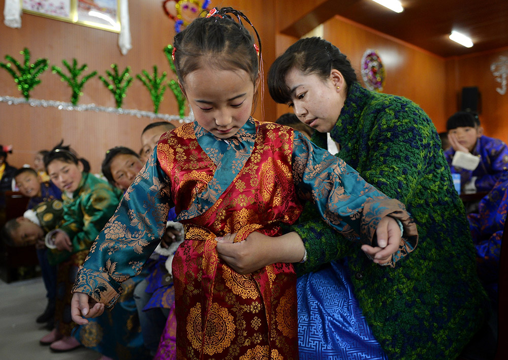 2月27日，在西藏自治區(qū)兒童福利院，來自拉薩市尼木縣的“愛心媽媽”德慶旺姆（右）在為來自那曲地區(qū)的嘎瑪曲宗換上節(jié)日盛裝。